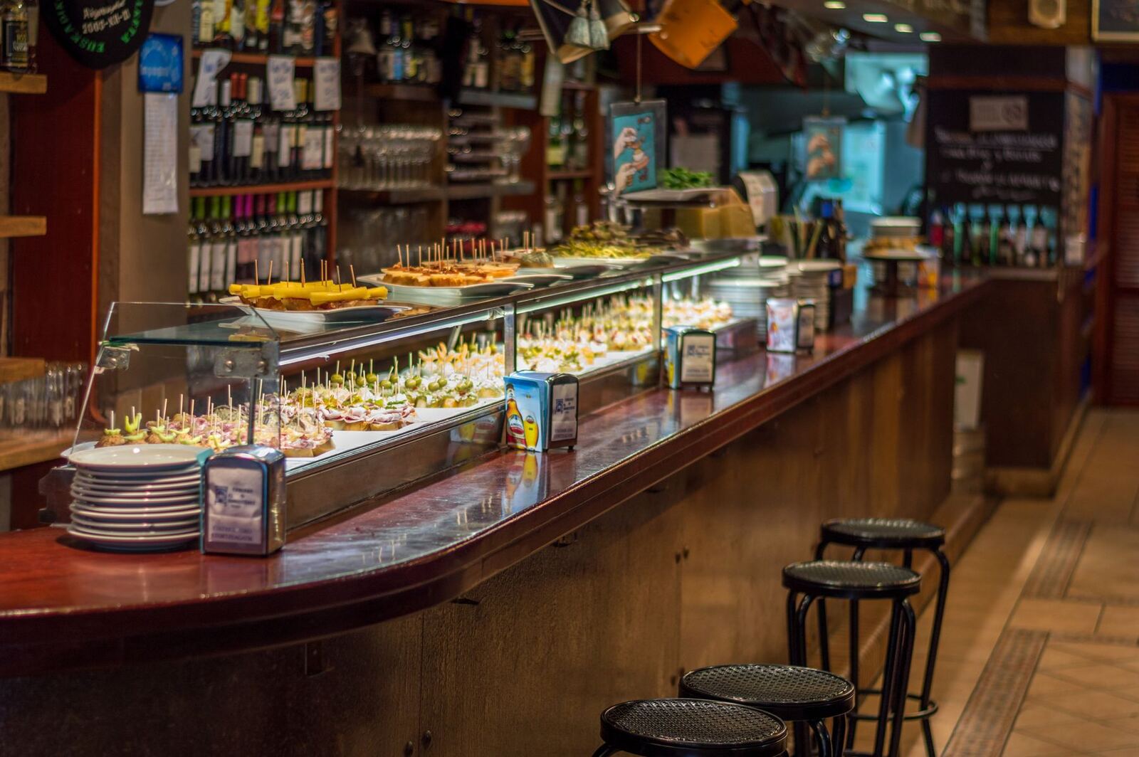 Barra de un bar de tapas con la vitrina llena de pinchos